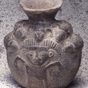 Disc flask decorated in relief with a male character