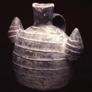 Flask with shell-shaped side sockets with horizontal lines engraved