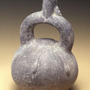 Globular vase with bracket loop with plastic figurine between loop and neck