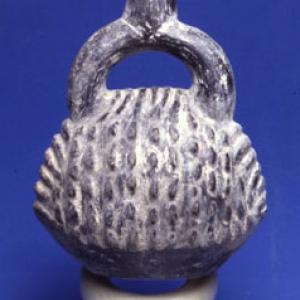 Vase with a bracket shaped like a fruit (or a shell?)